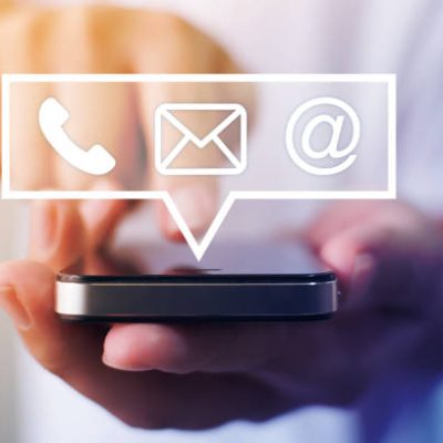 Close-up image of male hands using smartphone with icon telephone email mobile phone and address. Contact us connection and e-mail marketing concept